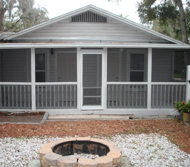 rear view of property with an outdoor fire pit