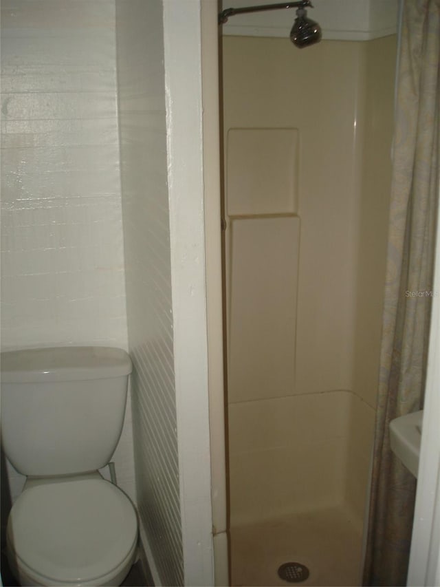 bathroom featuring a shower with curtain and toilet