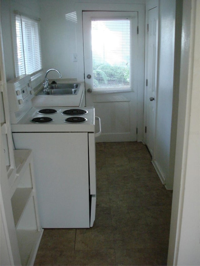 kitchen with white range with electric cooktop, sink, and dark tile patterned floors