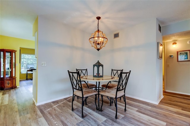 dining area featuring a chandelier and wood-type flooring