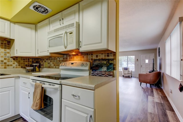 kitchen featuring white cabinets, decorative backsplash, and white appliances