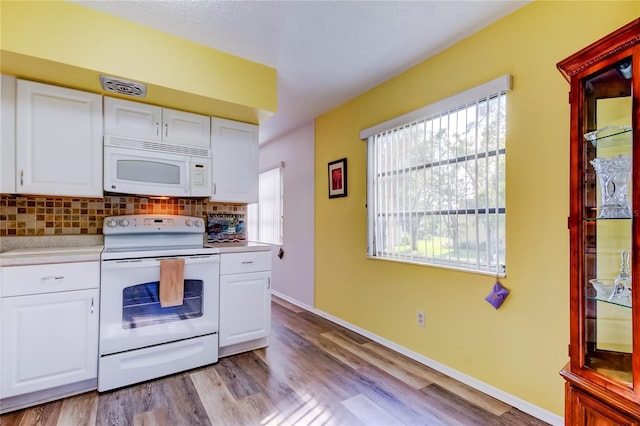 kitchen with white cabinets, light wood-type flooring, white appliances, and backsplash