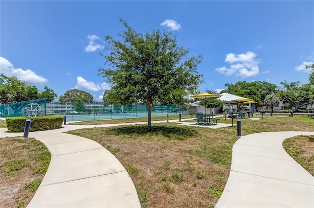 view of property's community featuring a lawn, a gazebo, and tennis court