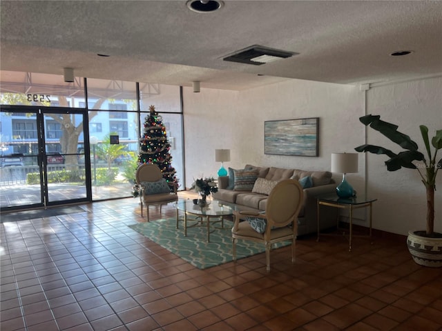 tiled living room with expansive windows and a textured ceiling