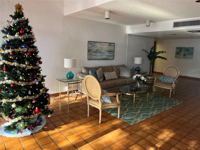 living room with tile patterned floors and a textured ceiling