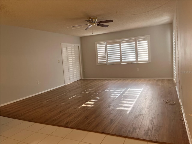 spare room featuring ceiling fan, a textured ceiling, and light hardwood / wood-style flooring