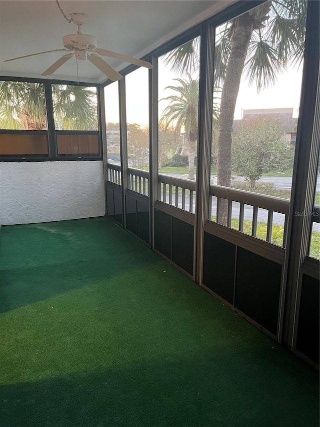 unfurnished sunroom with ceiling fan