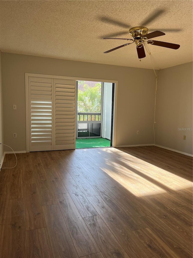 unfurnished room with ceiling fan, wood-type flooring, and a textured ceiling