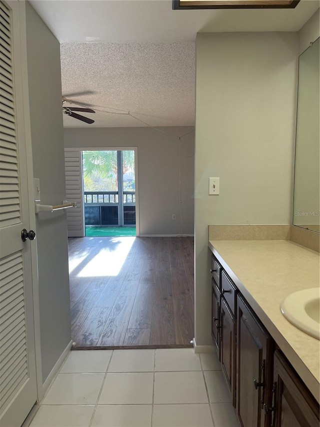 bathroom with a textured ceiling, vanity, tile patterned floors, and ceiling fan