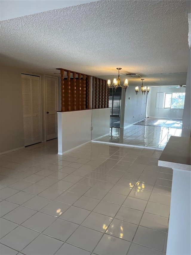 empty room featuring light tile patterned flooring and an inviting chandelier