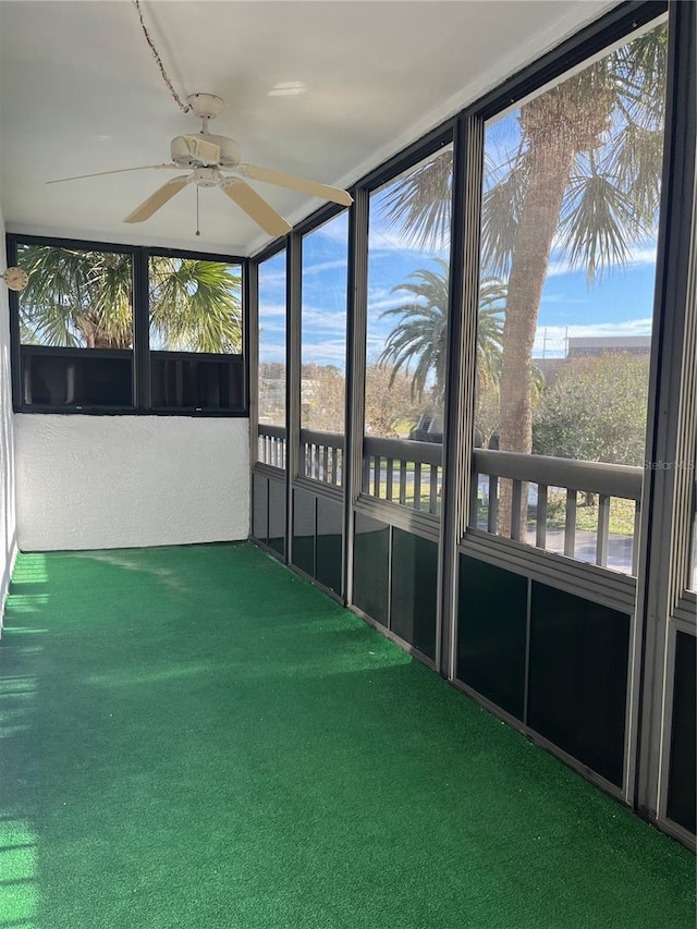 unfurnished sunroom with ceiling fan