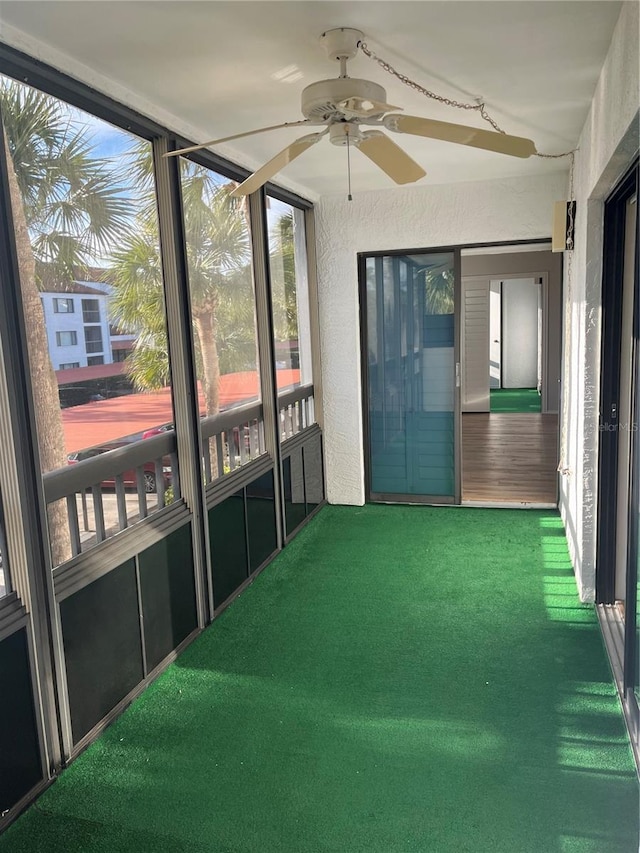 unfurnished sunroom with ceiling fan