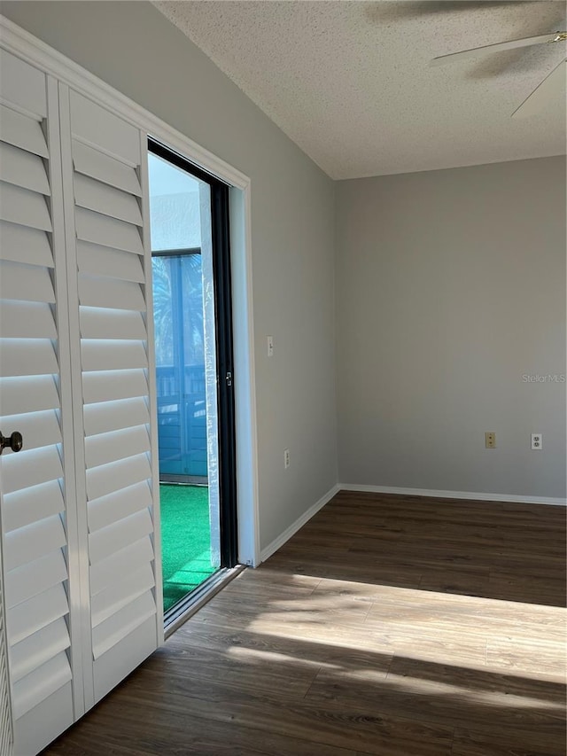 spare room with ceiling fan, dark hardwood / wood-style flooring, and a textured ceiling