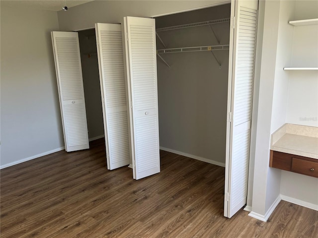 unfurnished bedroom with dark hardwood / wood-style floors and a closet