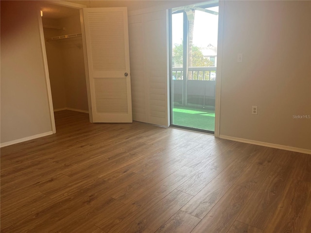 2593 Countryside Blvd Unit 7213, Clearwater, FL 33761 - unfurnished bedroom with access to outside, dark wood-style floors, a spacious closet, and a closet