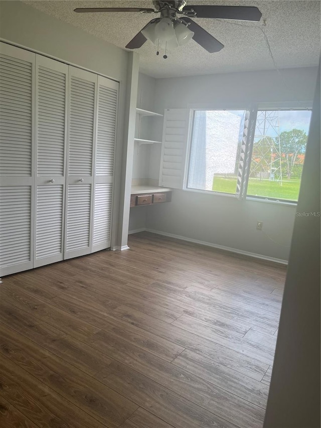 2593 Countryside Blvd Unit 7213, Clearwater, FL 33761 - unfurnished bedroom featuring a textured ceiling, wood finished floors, a closet, and a ceiling fan