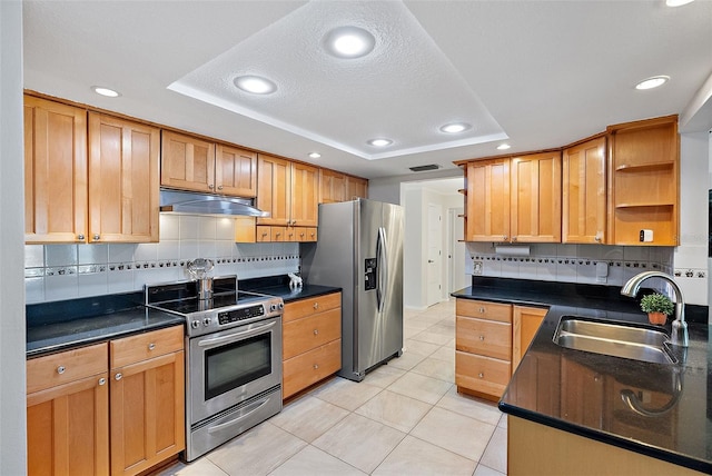 kitchen featuring light tile patterned flooring, a raised ceiling, sink, and appliances with stainless steel finishes