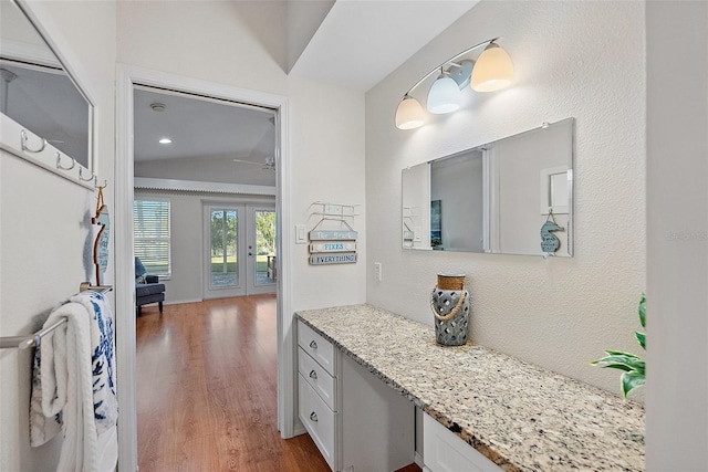 bathroom featuring french doors, vanity, vaulted ceiling, and hardwood / wood-style floors