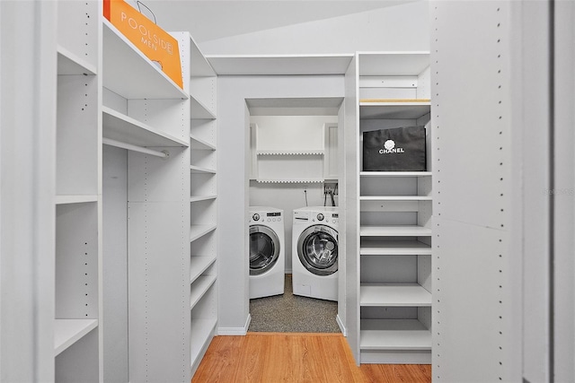 clothes washing area featuring separate washer and dryer and hardwood / wood-style flooring