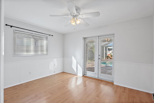 empty room featuring ceiling fan, light wood-type flooring, and french doors