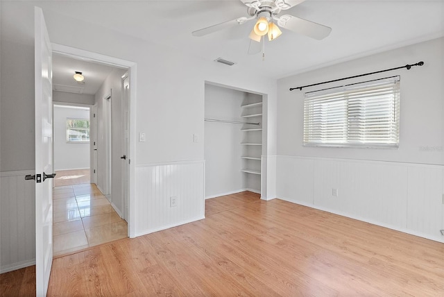 unfurnished bedroom featuring ceiling fan, a closet, and light hardwood / wood-style flooring