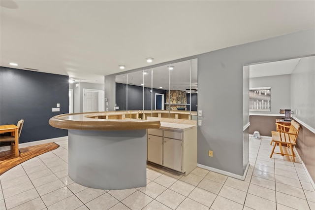 kitchen featuring white cabinets, a center island, and light tile patterned floors