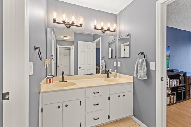 bathroom with a textured ceiling, vanity, and tile patterned floors