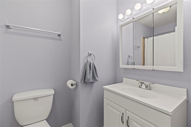 bathroom with curtained shower, vanity, and toilet