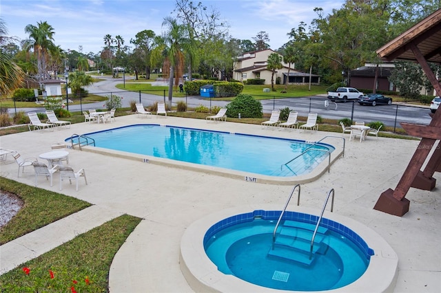 view of swimming pool featuring a community hot tub and a patio area