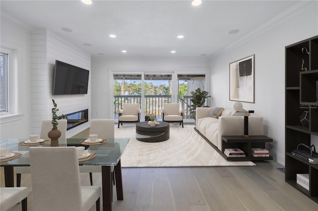 living room with hardwood / wood-style flooring, crown molding, and a fireplace