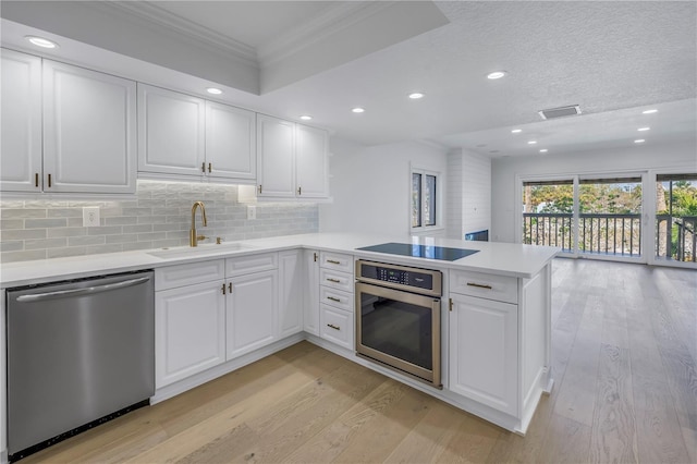 kitchen featuring white cabinetry, appliances with stainless steel finishes, kitchen peninsula, and sink