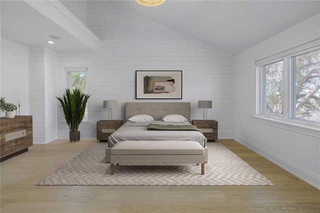 bedroom featuring light hardwood / wood-style flooring and high vaulted ceiling