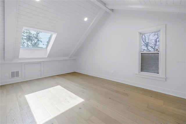 bonus room with vaulted ceiling with skylight and light wood-type flooring