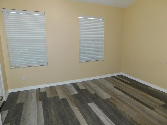 empty room featuring baseboards and wood finished floors