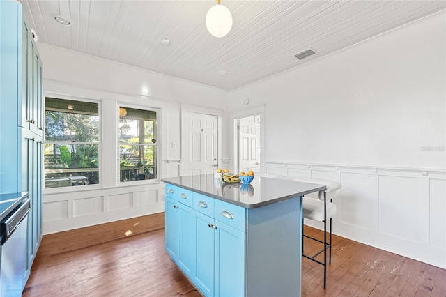 kitchen featuring wooden ceiling, dark wood-type flooring, stainless steel dishwasher, a kitchen island, and a kitchen bar