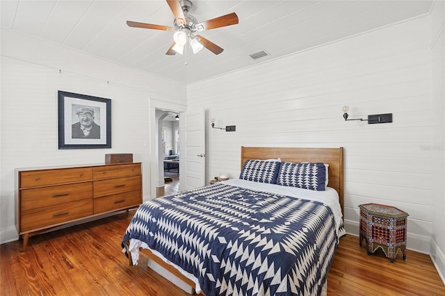 bedroom with dark hardwood / wood-style flooring and ceiling fan