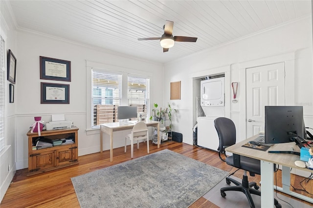 office area with ceiling fan, light hardwood / wood-style floors, stacked washer and clothes dryer, and wooden ceiling