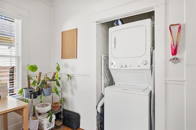 washroom with plenty of natural light, stacked washing maching and dryer, and ornamental molding