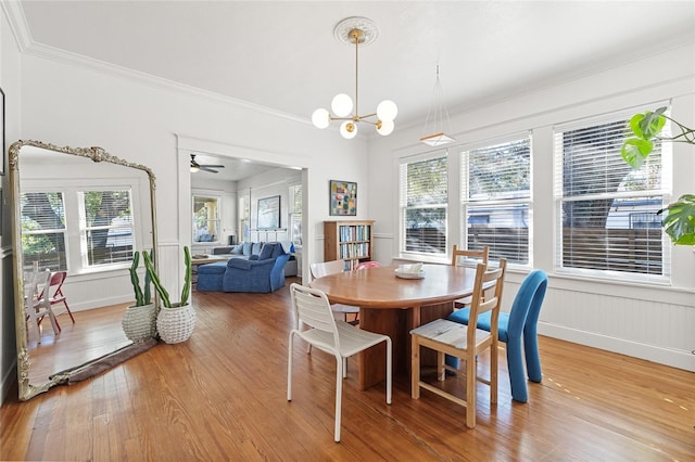 dining room with hardwood / wood-style floors, ceiling fan with notable chandelier, and plenty of natural light