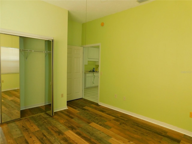 unfurnished bedroom with a closet and dark wood-type flooring