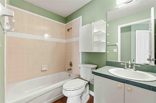 bathroom with a textured ceiling, shower / tub combination, toilet, wood finished floors, and vanity