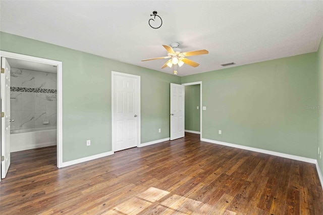 unfurnished bedroom featuring dark wood-style floors, visible vents, baseboards, and a ceiling fan