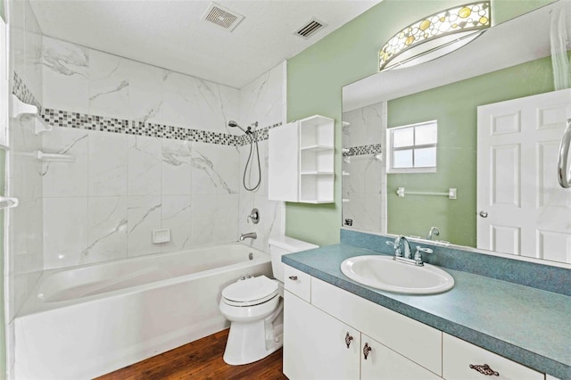 bathroom featuring toilet, wood finished floors, shower / tub combination, and visible vents