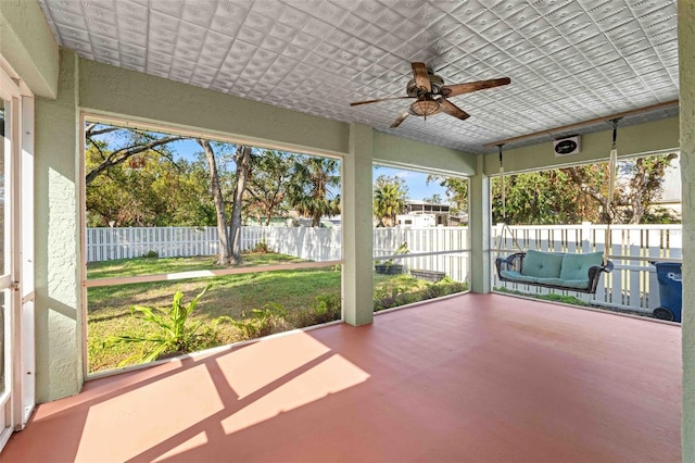 unfurnished sunroom featuring ceiling fan