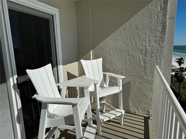 balcony featuring a water view and a view of the beach