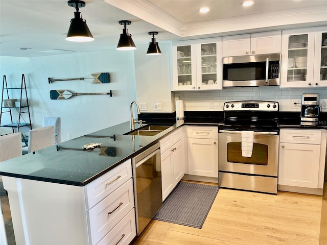 kitchen featuring white cabinets, appliances with stainless steel finishes, hanging light fixtures, and sink