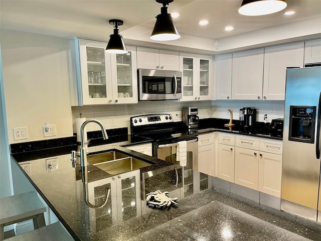 kitchen featuring decorative light fixtures, stainless steel appliances, white cabinetry, and sink