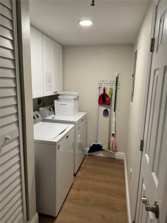 laundry area featuring dark hardwood / wood-style flooring, cabinets, separate washer and dryer, and electric panel