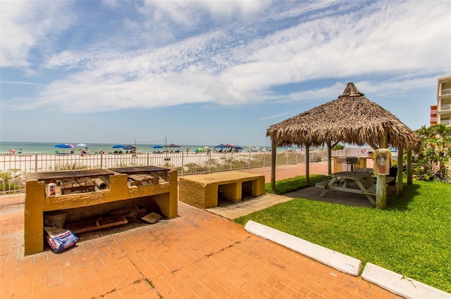 view of property's community featuring a gazebo, a water view, and a lawn