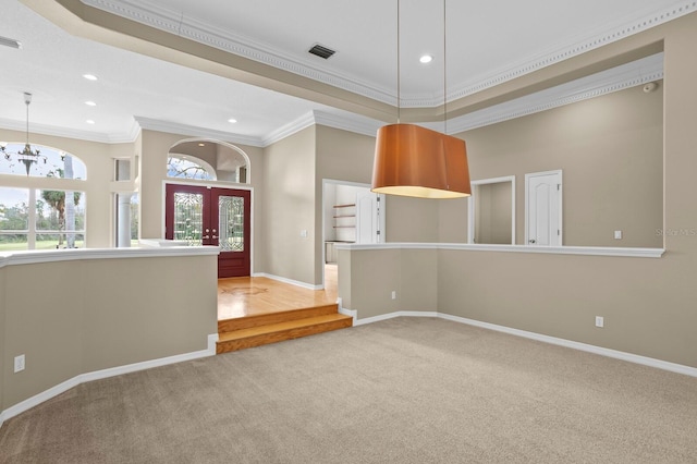 empty room with carpet, french doors, ornamental molding, a chandelier, and a tray ceiling